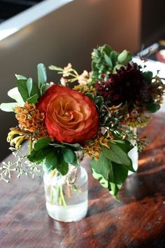 a vase filled with flowers on top of a wooden table