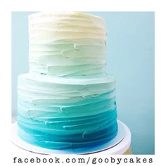 a multi layer cake with white, blue and green frosting