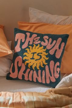 the sun shining pillow is on top of a bed