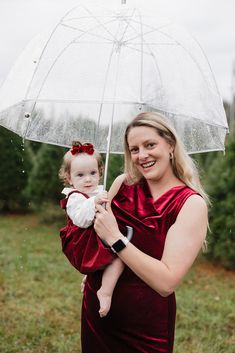 a woman holding a baby under an umbrella