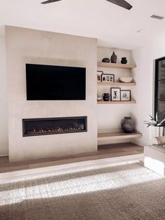 a living room with a large flat screen tv mounted on the wall above a fireplace