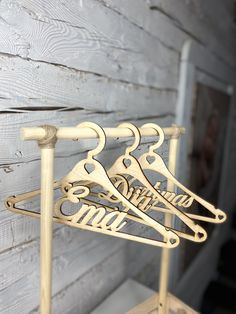 three wooden clothes hangers on a stand