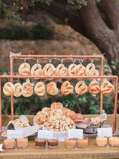 donuts and other food are displayed on an outdoor table