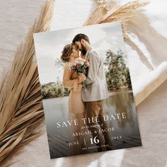 an image of a couple kissing in front of a photo save the date card for their wedding