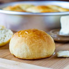 a loaf of bread sitting on top of a wooden cutting board next to a pie pan