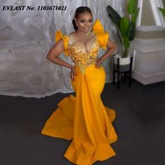 a woman in a yellow gown posing for the camera with her hands on her hips