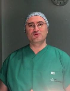 a man in green scrubs is giving the thumbs up while standing next to a mirror