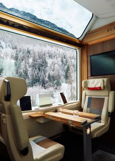 the interior of a train car with mountains in the background