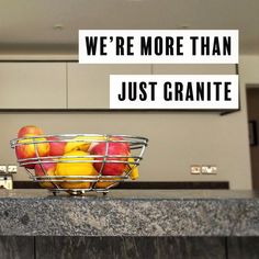 a metal basket filled with apples on top of a counter