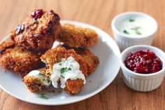 some food is sitting on a white plate with cranberry sauce and sour cream