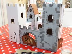 a castle made out of cardboard sitting on top of a red and white table cloth