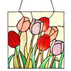 a stained glass window with red and pink tulips in the center, hanging on a chain