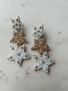 Add some celestial charm to your look with Treasure Jewels' White & Gold Star Earrings. Hand beaded with shining gold and white stars, these earrings are the perfect accessory for any outfit. Shine like a star with these unique earrings. Length: 3in Lightweight Post with backing Shine Like A Star, Gold Star Earrings, Maxi Outfits, White Stars, Jumpsuit Shorts Rompers, Gold Star, Wedding Night, Star Earrings, Gold Stars