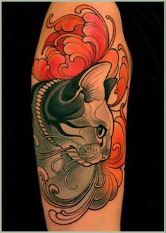 a black and white cat with red clouds on it's back leg tattoo design