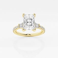 a yellow gold engagement ring with a cushion cut diamond and baguettes on the side