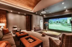 a man is playing golf on the television screen in this living room with couches and chairs