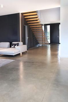 a living room with a white couch and stairs