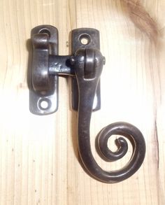 an old door handle on a wooden surface with a spiral design in the center and bottom