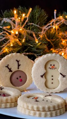 cookies decorated like snowmen with christmas lights in the background