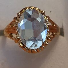 an oval shaped blue topaz ring with gold accents