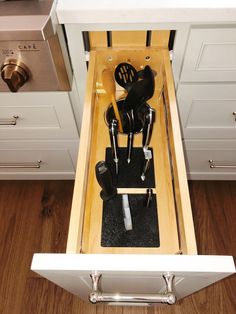 an open drawer with utensils in it