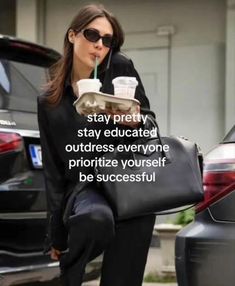 a woman in black jacket carrying a bag and drinking from a cup with quote on it