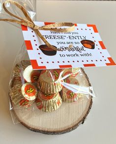 some kind of candy wrapped in cellophane and tied with ribbon on top of a piece of wood