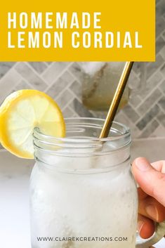 a hand holding a lemonade drink in a mason jar with the words homemade lemon cordial