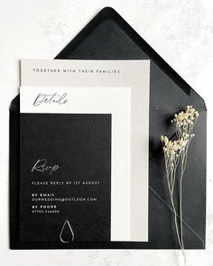 a black and white wedding suite with flowers on the table next to it is an envelope that says, together with their families