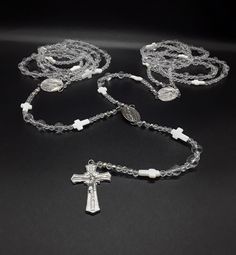 The Silver Wedding Lasso Rosary is an exclusive, special and unique Rosary designed for the special moment in your life. Created for the couple that wishes for a high class wedding lasso Rosary.  In regards to the beads. The beads are made of triple-A high quality Natural Quartz Crystal Beads; completely cleansed and purified. Second, its crosses: there are two types of crosses. The smaller ones that appear along the lasso rosary and are made of the famous Fildisi. The large cross is made of pur Silver Wedding Rosary With 8mm Beads, Silver Wedding Rosary With Round Beads, White Sterling Silver Jewelry With Faceted Beads, Spiritual Silver Beads Jewelry For Weddings, White 8mm Beads Jewelry For Anniversary, Silver Jewelry With 8mm Beads For First Communion, Silver Spiritual Jewelry For First Communion, Spiritual Silver Jewelry For First Communion, Handmade Silver Wedding Rosary