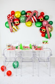 a table with christmas decorations and balloons on the wall