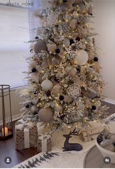 a white christmas tree with silver and gold ornaments