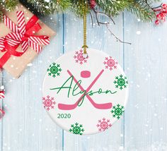 a personalized ornament hanging from a christmas tree on a blue wooden background