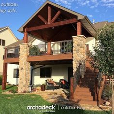 a large house with an attached deck and stone pillars