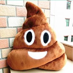 a brown poop shaped pillow sitting on top of a counter next to a brick wall