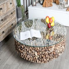 a glass table with rocks on it and an open book sitting on top of it