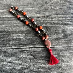 The Root Chakra Intention Bracelet, made with Red Jasper, Smoky Quartz, and Hematite, is designed to help you feel grounded and balanced. Use this piece to instill a sense of stability, strength, and security. Materials: 8mm Red Jasper, Smoky Quartz, and Hematite beads 12x18mm Rhodonite focal stone brown C-lon thread 1.25" deep red silky tassel silver plated accent beads Every bead is lovingly strung on thread and hand-knotted between each stone, embodying the essence of patience and devotion. Y Red Meditation Bracelets With 8mm Beads, Red Spiritual Beaded Bracelets For Meditation, Red Beaded Bracelets For Meditation 8mm, Red Bracelets With 8mm Beads For Meditation, Red Beaded Bracelets With Natural Stones For Meditation, 8mm Bead Bracelet For Meditation, Spiritual Hematite Beaded Bracelets, Red Gemstone Beads Bracelets For Meditation, Red Spiritual Bracelets For Healing