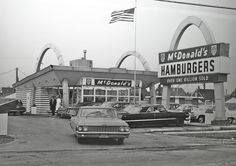 an old black and white photo of a mcdonald's with cars parked in front