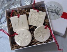 three white ceramic ornaments in a gift box