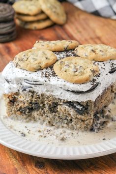 a piece of cake on a plate with cookies and oreo cookies in the background