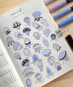 an open notebook with jellyfish stickers on it and some markers next to it