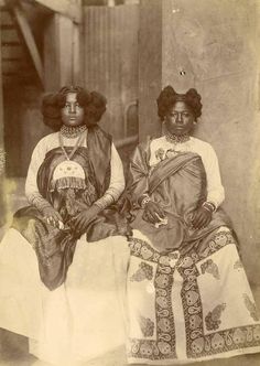 an old photo of two women sitting next to each other