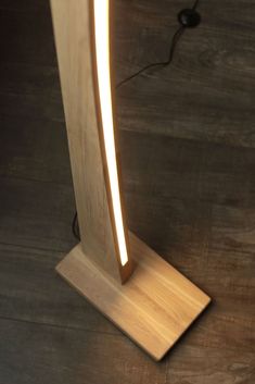 a wooden floor lamp on top of a hard wood floor