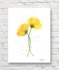 two yellow flowers are shown against a white brick wall with watercolor paint on it