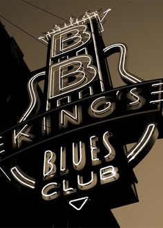 the neon sign for blues club is lit up