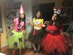 three girls dressed up in costumes standing next to each other