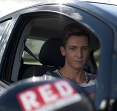 a man sitting in the driver's seat of a car