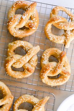 several pretzels on a cooling rack with sesame seed sprinkled in them