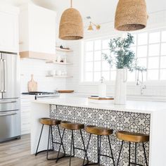 three stools sit in front of a kitchen island