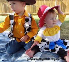 two young children dressed in costumes sitting on the ground